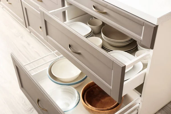 Set of dishes in open kitchen drawers, closeup