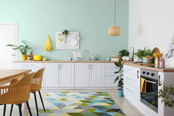 白いカウンターと緑の壁にぶら下がっているペグボードとスタイリッシュなキッチンのインテリア — ストック写真
