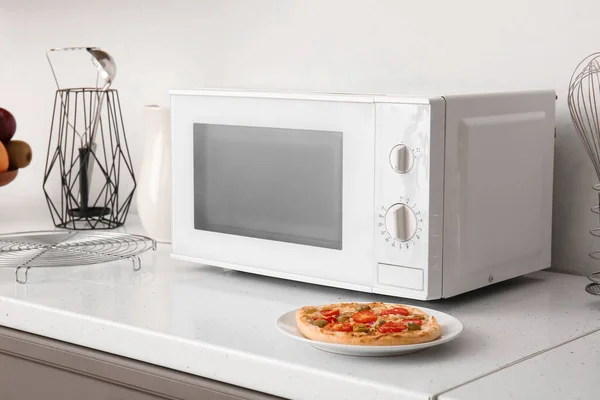 Moderne Mikrowelle Und Teller Mit Pizza Auf Der Theke Der — Stockfoto