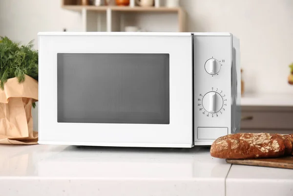 Modern microwave oven and food on counter in kitchen, closeup