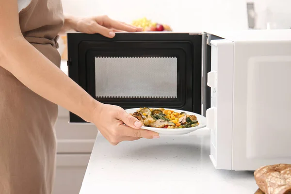 Woman Putting Plate Vegetables Microwave Oven Kitchen — Stock Photo, Image