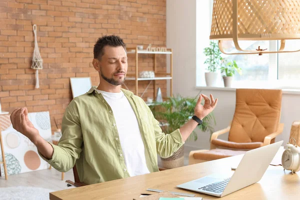 Ofiste meditasyon yapan yakışıklı bir adam.