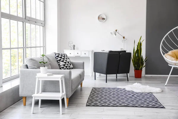 Beyaz basamaklı iskemle ve kanepeli oturma odasının içi.