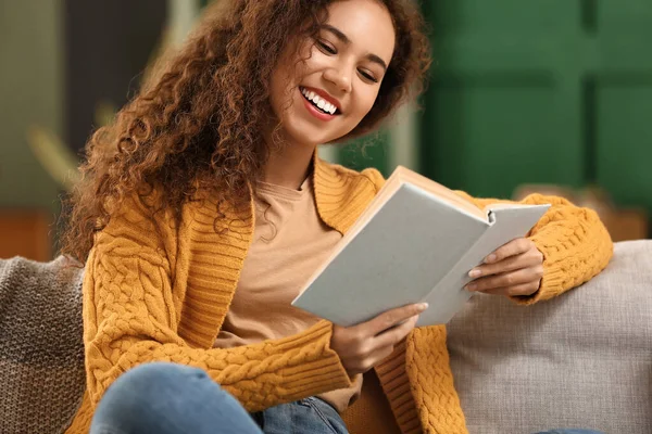 Young African American Woman Yellow Cardigan Reading Book Sofa Home — Stock Photo, Image