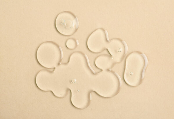 Many drops of liquid transparent gel with bubbles on color background