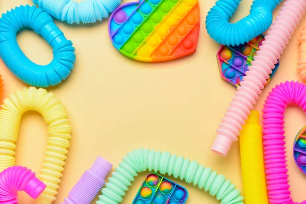 Renkli pop tüplerinden yapılmış çerçeve ve sarı arka planda hareketli oyuncaklar