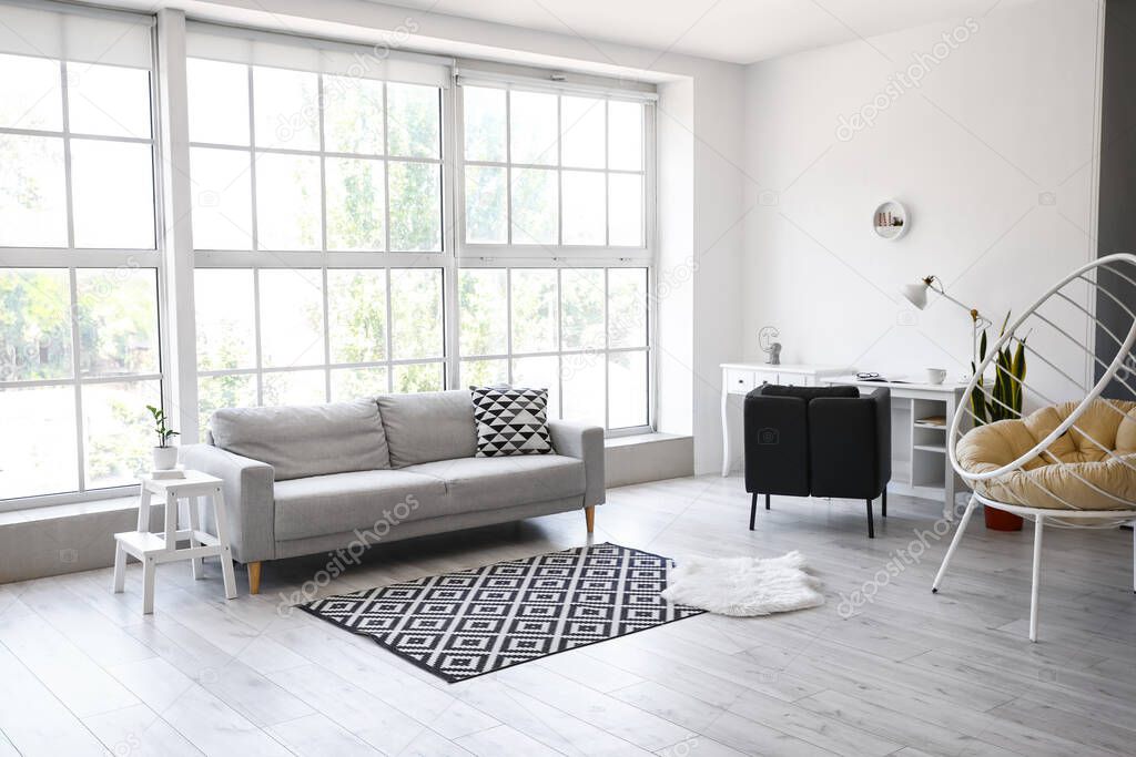 Interior of light living room with sofa and white step stool
