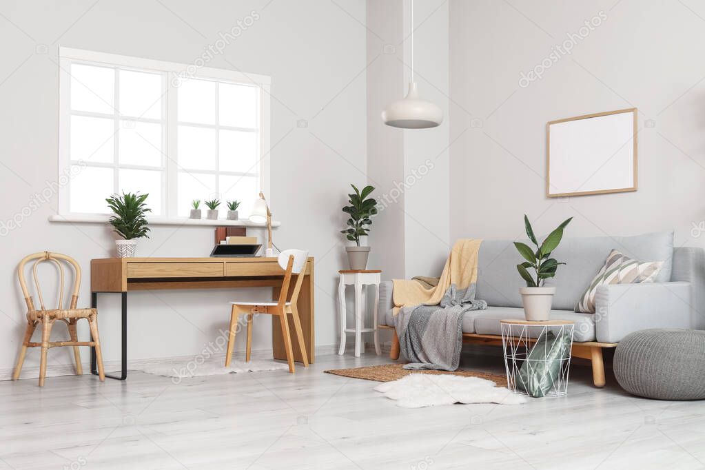 Interior of modern living room with sofa, workplace and houseplants