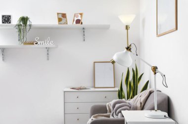 Lambaları, koltuğu ve tuvaleti olan bir oturma odası.