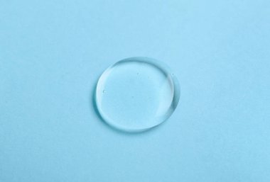 Mavi arkaplanda sıvı şeffaf jel damlası