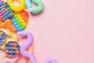 Renkli pop tüpleri ve patlayan oyuncaklar pembe arka planda