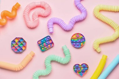 Renkli pop tüpleri ve patlayan oyuncaklar pembe arka planda