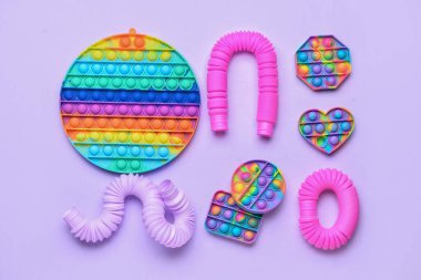 Renkli pop tüpleri ve mor arka planda hareketli oyuncaklar