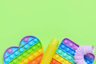 Renkli pop tüpleri ve patlayan oyuncaklar yeşil arka planda
