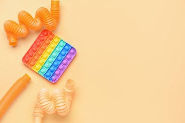 Renkli pop tüpleri ve bej arka planda hareketli oyuncaklar
