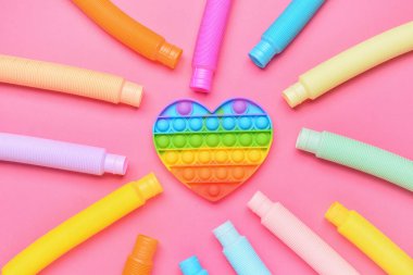 Renkli pop tüpleri ve pembe arka planda hareketli oyuncaklar
