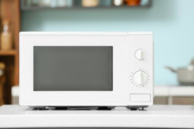 Beyaz mikrodalga fırın şık bir mutfakta tezgahta.