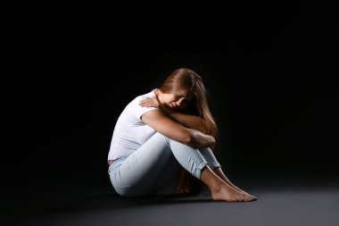 Karanlık arka planda korkmuş bir kadın. Şiddet kavramı