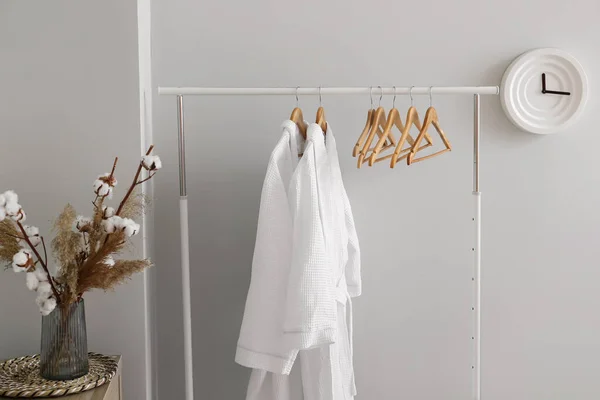 Rack Dengan Jubah Mandi Putih Dekat Dinding Cahaya Kamar — Stok Foto