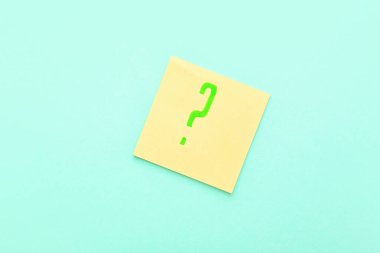 Mavi arkaplanda yeşil soru işareti olan yapışkan bir not