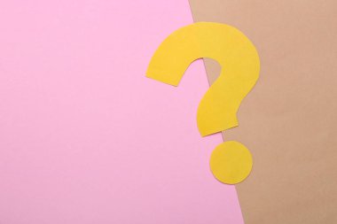 Renk arkaplanı üzerine sarı kağıttan yapılmış soru işareti