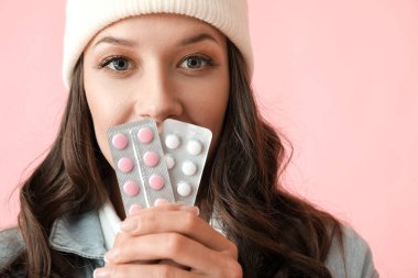 Arka planda haplarla su toplayan genç bir kadın.