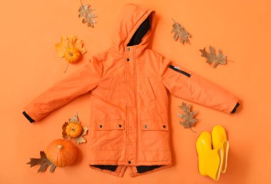 Çocuk ceketi, çizme ve arka planda sonbahar dekoru