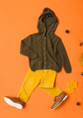 Şık çocuk kıyafetleri ve arka planda sonbahar dekoru.