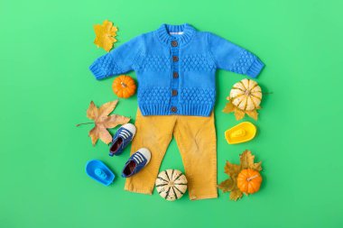 Şık erkek kıyafetleri, ayakkabılar ve arka planda sonbahar dekoru.