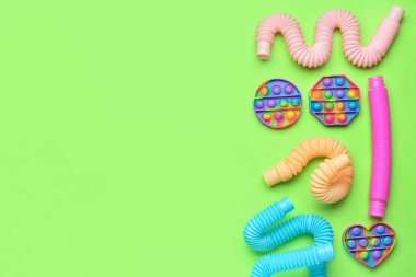 Renkli pop tüpleri ve patlayan oyuncaklar yeşil arka planda