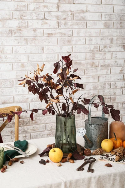 Stylish autumn composition on table near light brick wall