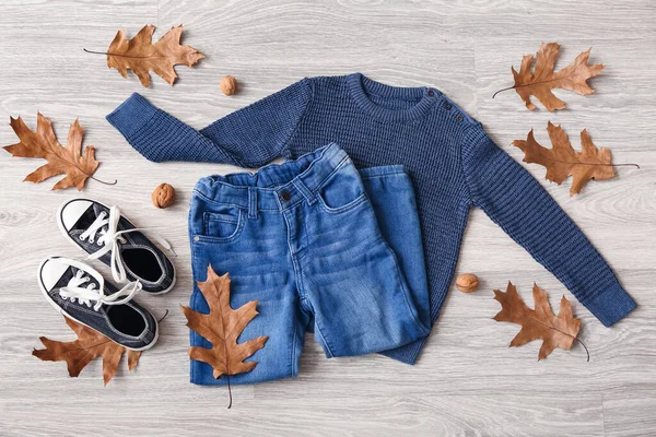 Babybekleidung Schuhe Und Herbstdekor Auf Grauem Holzgrund — Stockfoto