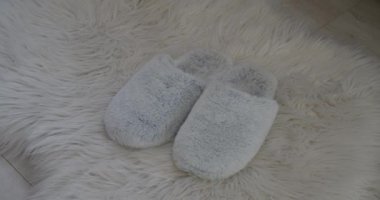 Genç bir kadın sabahları terliklerini giyiyor.