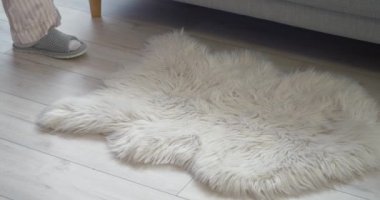 Genç kadın evde terliklerini çıkarıp kanepeye uzanıyor.