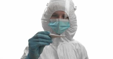 Koruyucu kıyafetli doktor beyaz arka plandaki hastaların sıcaklığını ölçüyor.