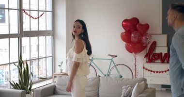 Sevgililer Günü 'nde elinde gül buketiyle kız arkadaşını selamlayan mutlu genç adam. 