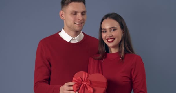 Ευτυχισμένο Νεαρό Ζευγάρι Φιλιά Δώρων Γκρι Φόντο Γιορτή Του Αγίου — Αρχείο Βίντεο