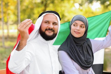 Geleneksel giyinmiş bir çift ve BAE 'nin ulusal bayrağı açık havada