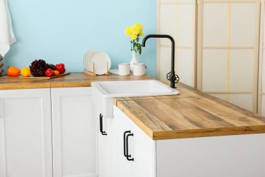 Beyaz tezgahlar ahşap masa üstü ve mutfak lavabosu.