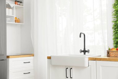 Işık perdesinin yanında lavabosu olan beyaz tezgahlar