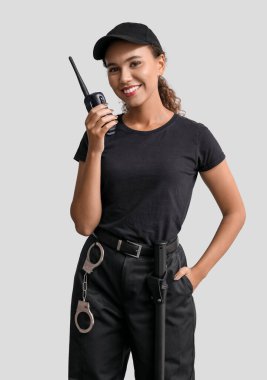 Hafif arka planda radyo vericisi olan Afro-Amerikalı kadın güvenlik görevlisi.