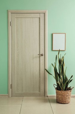 Duvarın yanında boş fotoğraf çerçevesi ve kapalı kapısı olan bir ev.