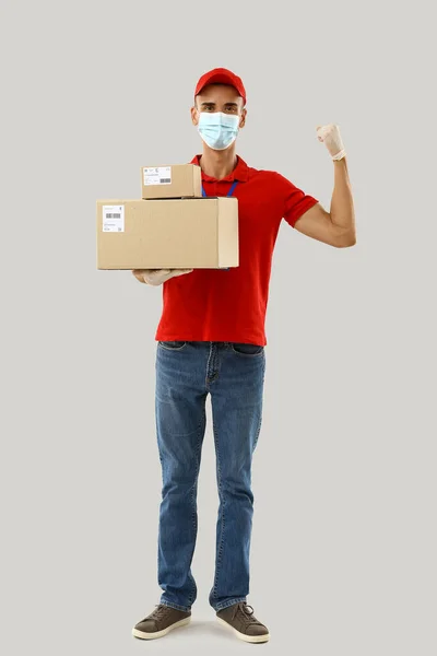 Strong Male Courier Medical Mask Parcels Light Background — Stock Photo, Image