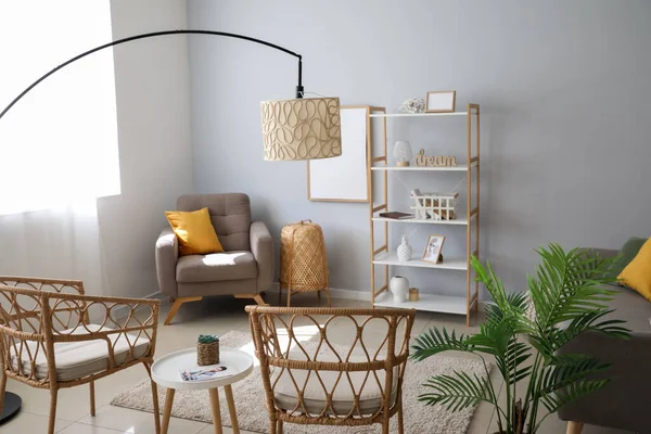 Lambaları, sandalyeleri ve rafları olan bir oturma odası.