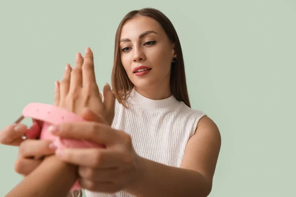 Young Woman Putting Handcuffs Sex Shop Her Partner Color Background — Fotografia de Stock