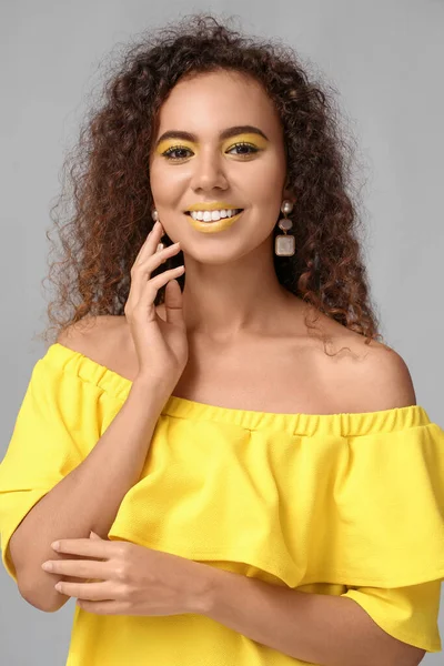 Hermosa Mujer Afroamericana Con Maquillaje Tonos Amarillos Sobre Fondo Gris —  Fotos de Stock