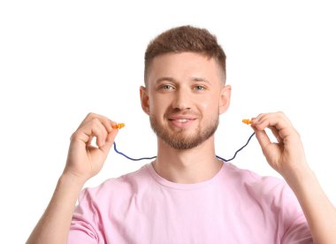 Beyaz arka planda kulak tıkacı olan genç bir adam.