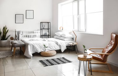 Beşiği ve büyük penceresi olan aydınlık yatak odasının içi