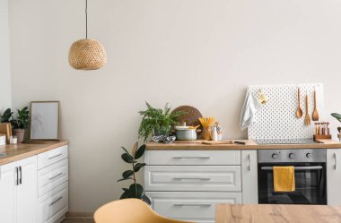 Beyaz tezgahlı, fırınlı ve çivili modern mutfağın içi.