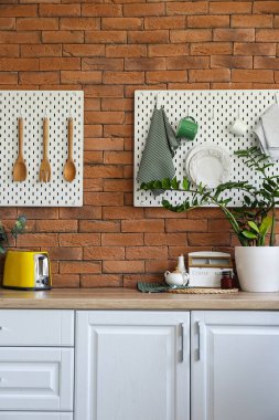 Tuğla duvarda mutfak gereçleri asılı Peg tahtaları